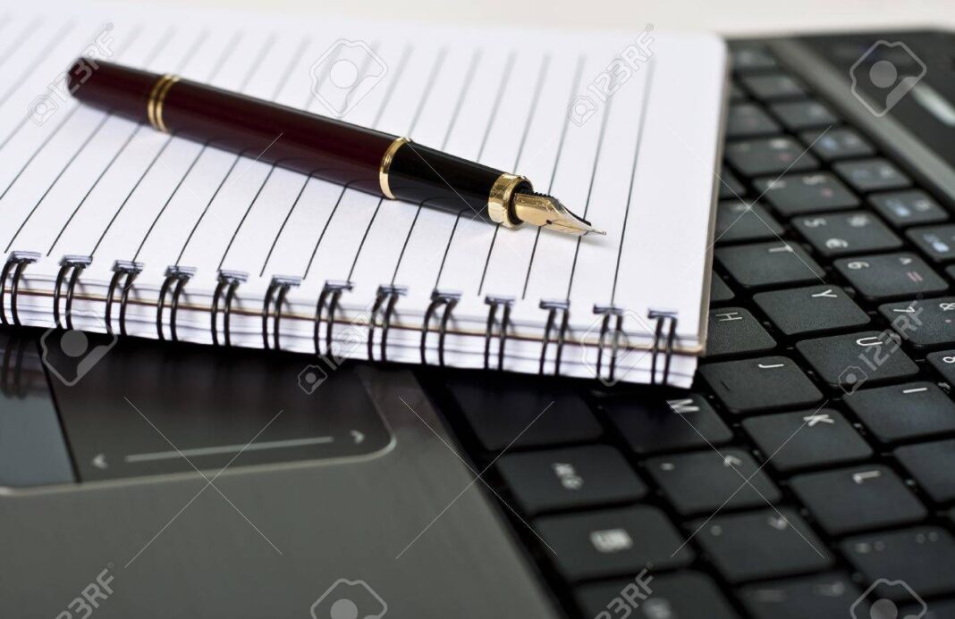12805945-pen-notepad-and-laptop-on-the-desk-in-the-office